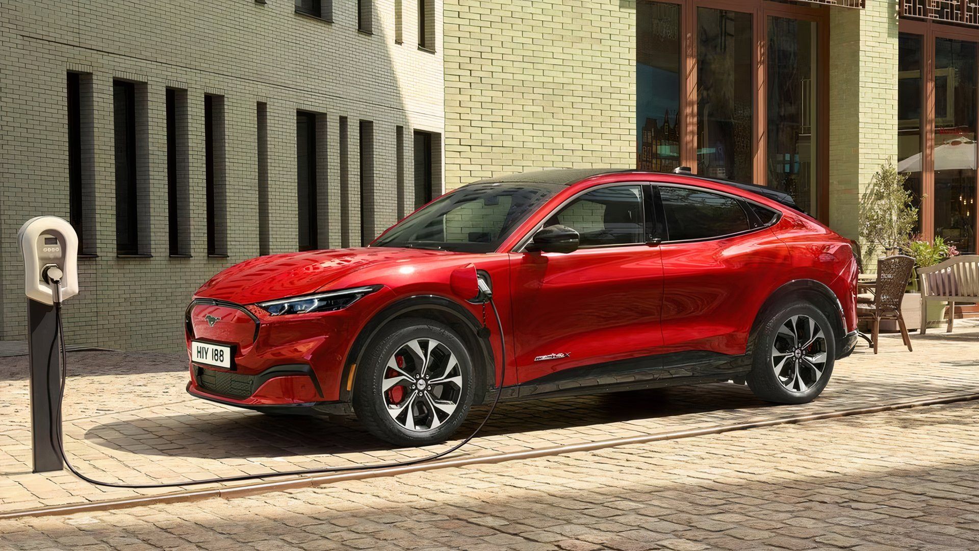 Side angle shot of the 2021 Ford Mustang Mach-E plugged into a charger