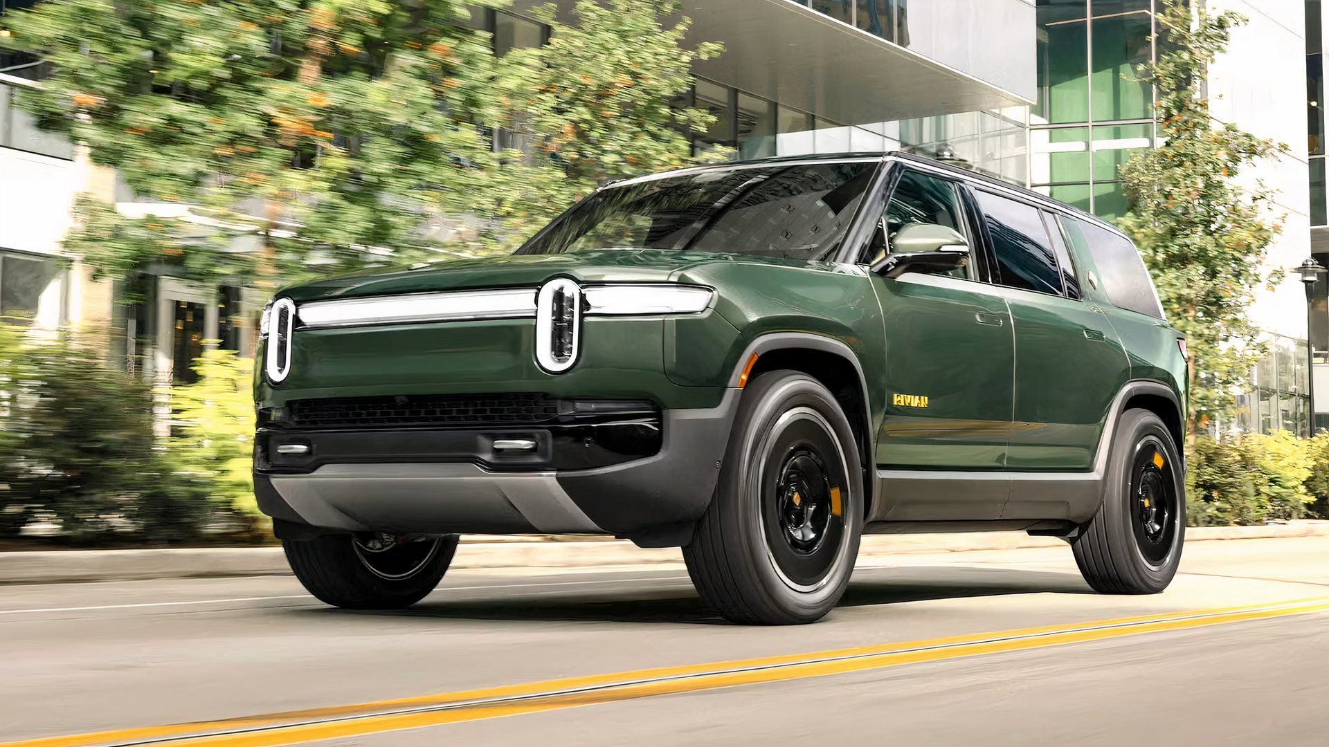 green 2025 Rivian R1S front driving