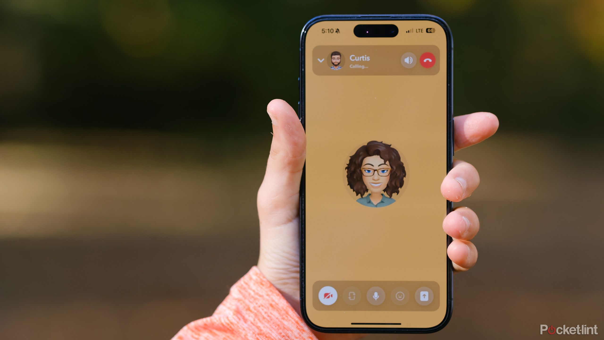 A hand holds an iPhone with a Snapchat video call