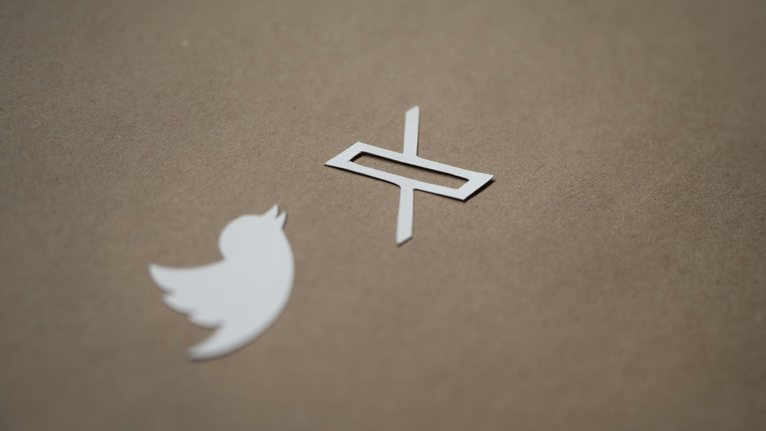 Twitter and X logos cut out of paper