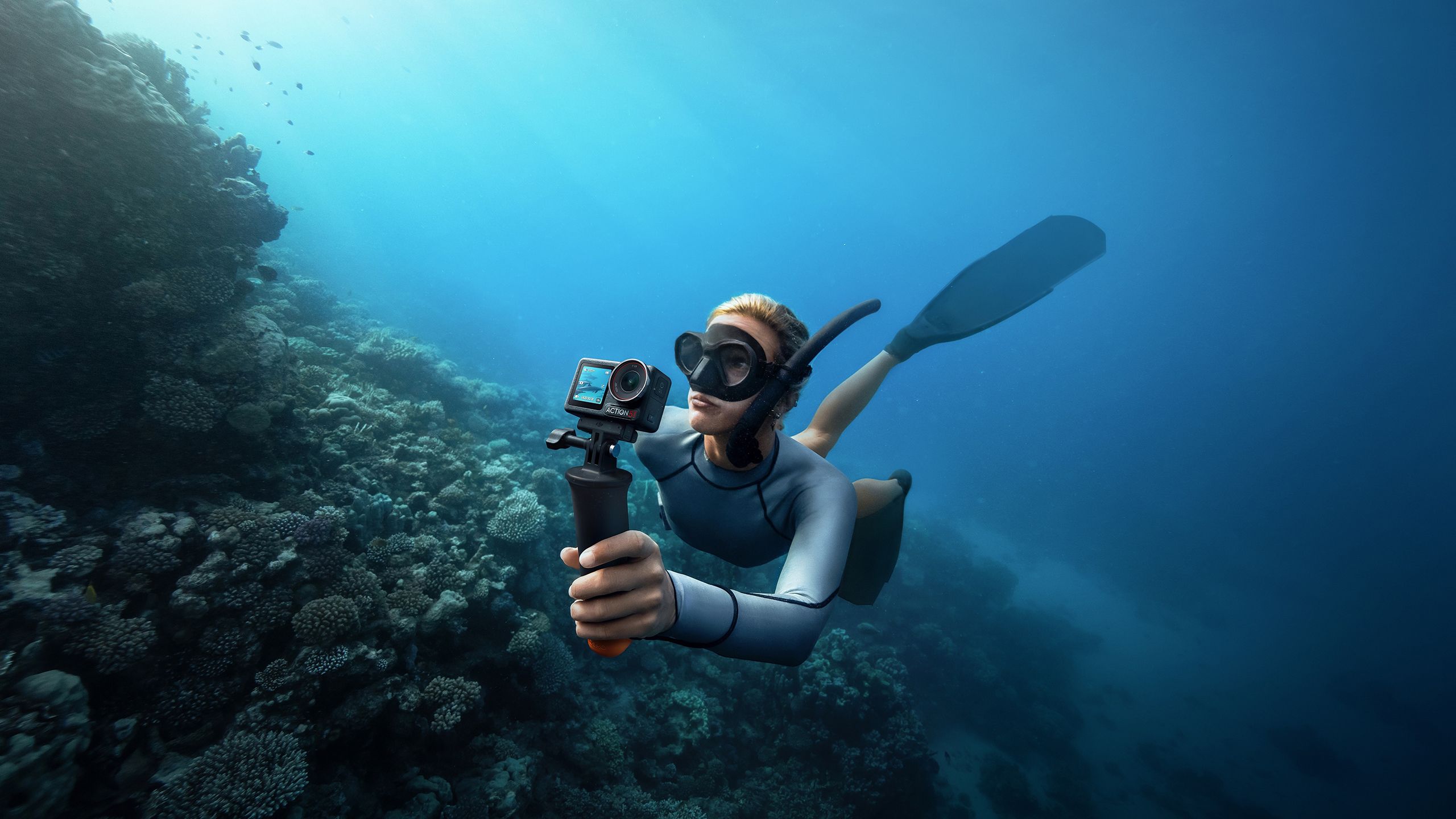 The DJI Osmo Action 5 Pro is held underwater