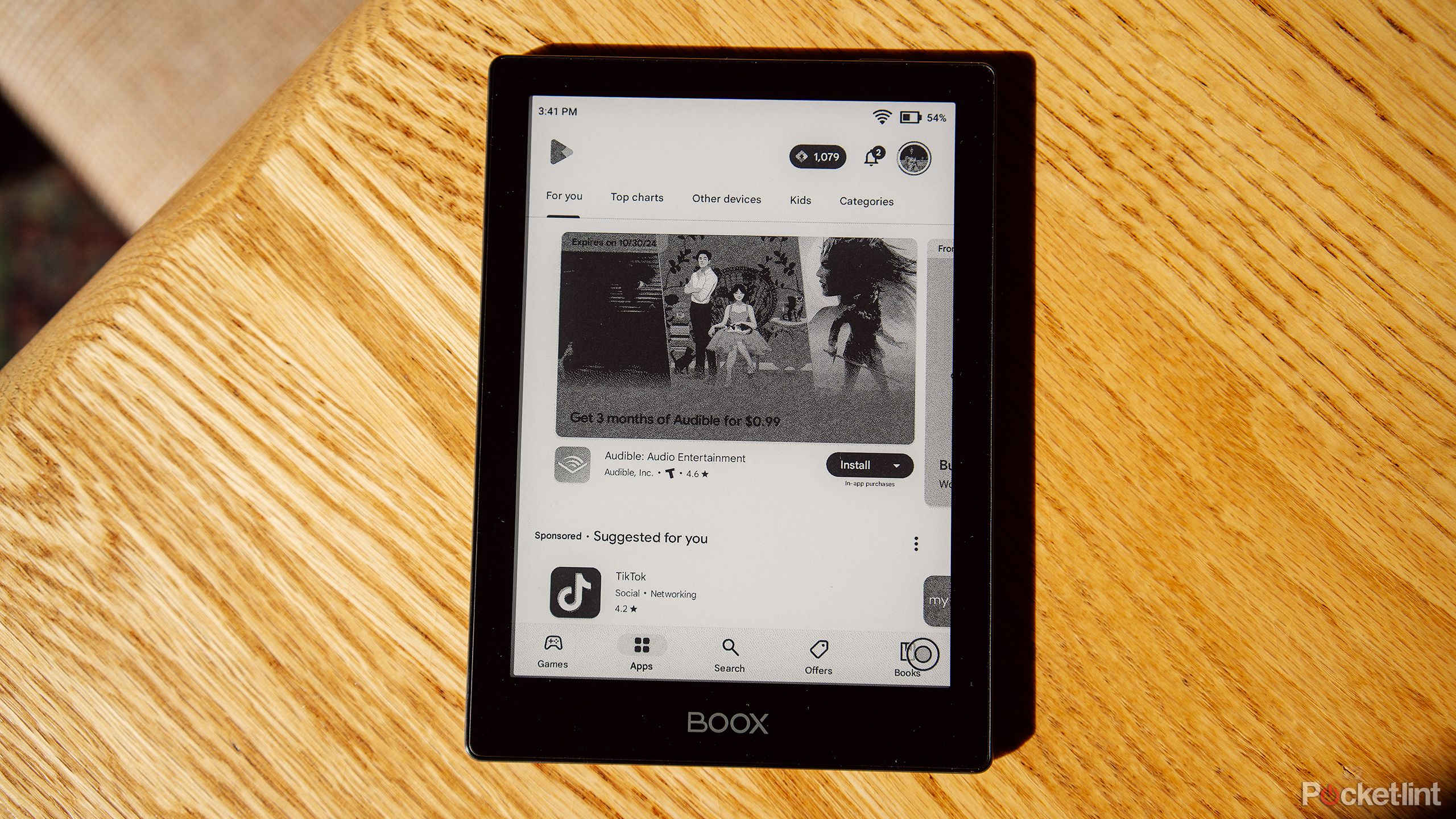 The Boox Go 6 e-reader sits on a wood table with the Google Play Store on the display. 