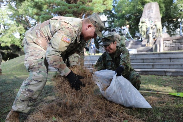 765th Transportation (Terminal) Bn. Soldiers, Japan Ground Self-Defense Force members work together to beautify historical stone monument on Camp Zama