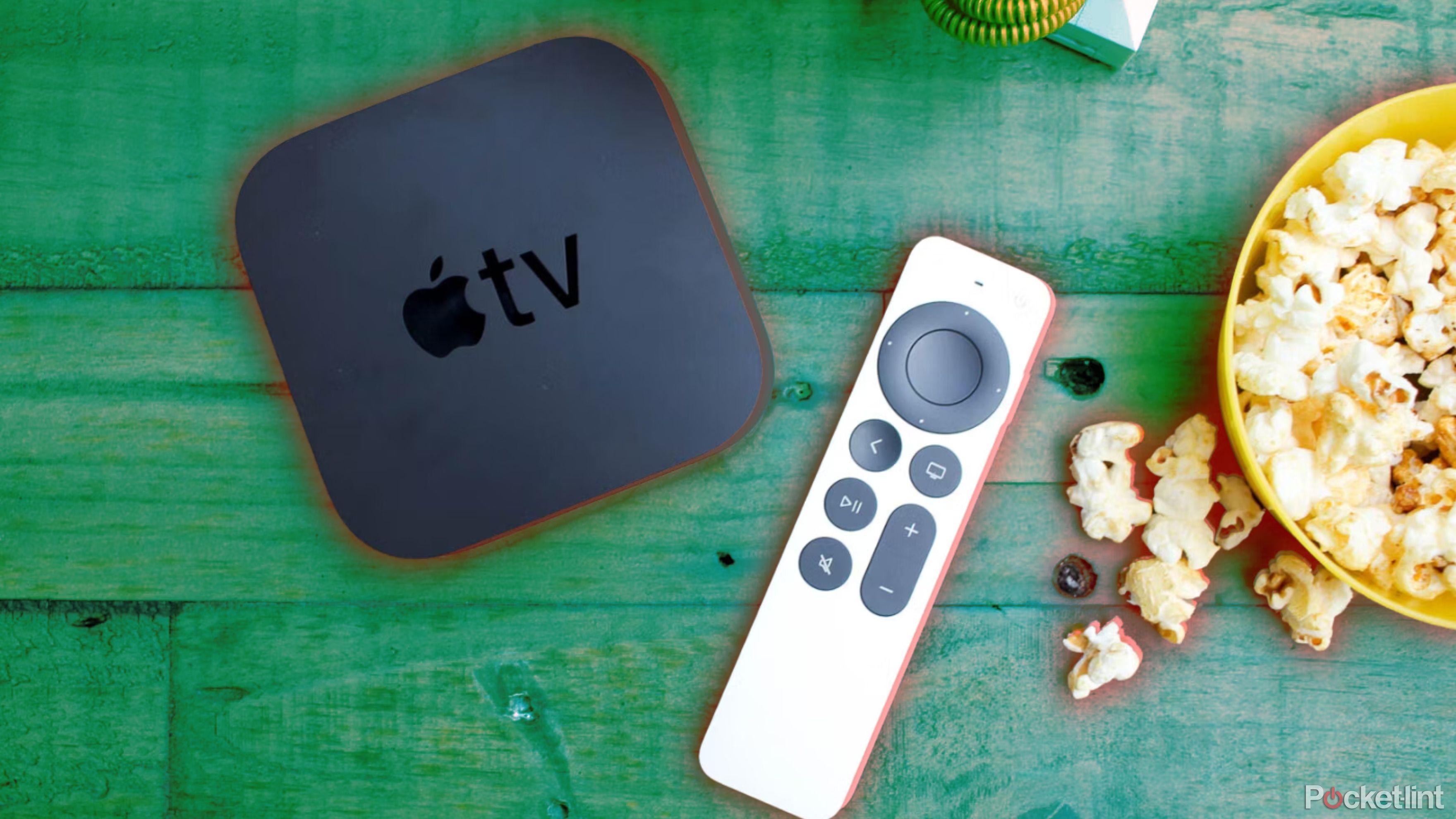 Apple TV and remote on wood table with popcorn