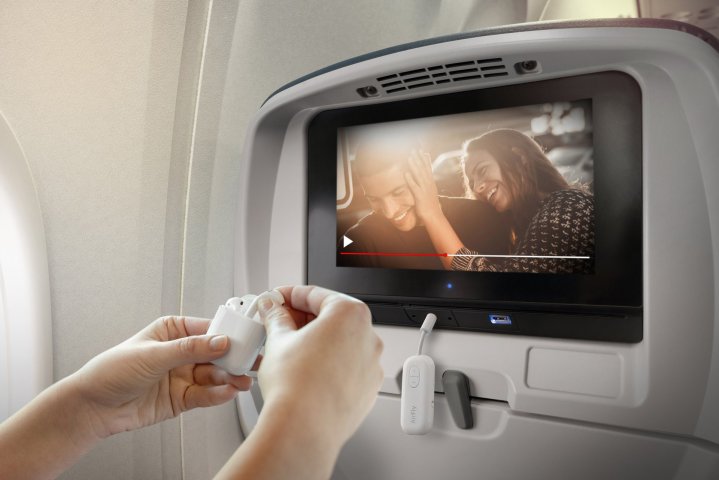 Hands connecting the Twelve South AirFly Pro to a airplane's entertainment system.