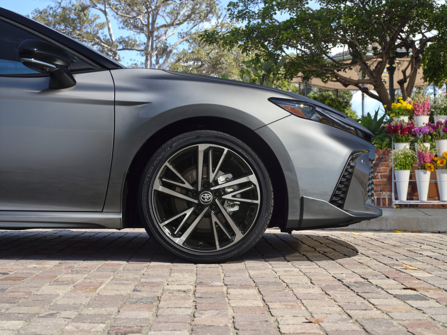 a car wheel parked on cobblestone street