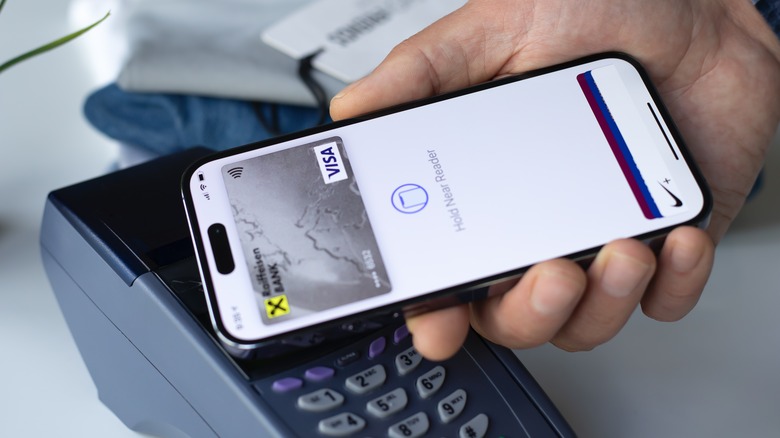 Person making a contactless payment using an iPhone