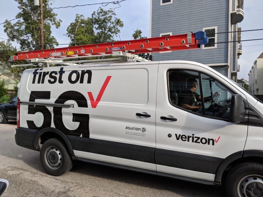 Man driving white Verizon 5G van