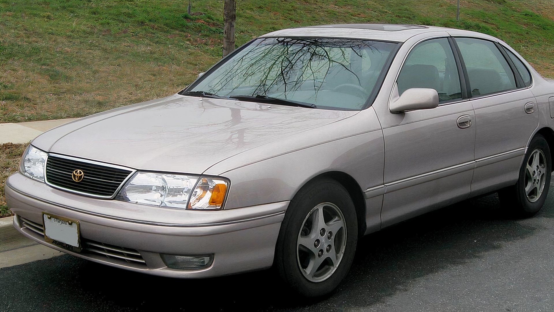 Tan 1999 Toyota Avalon parked next to a curb