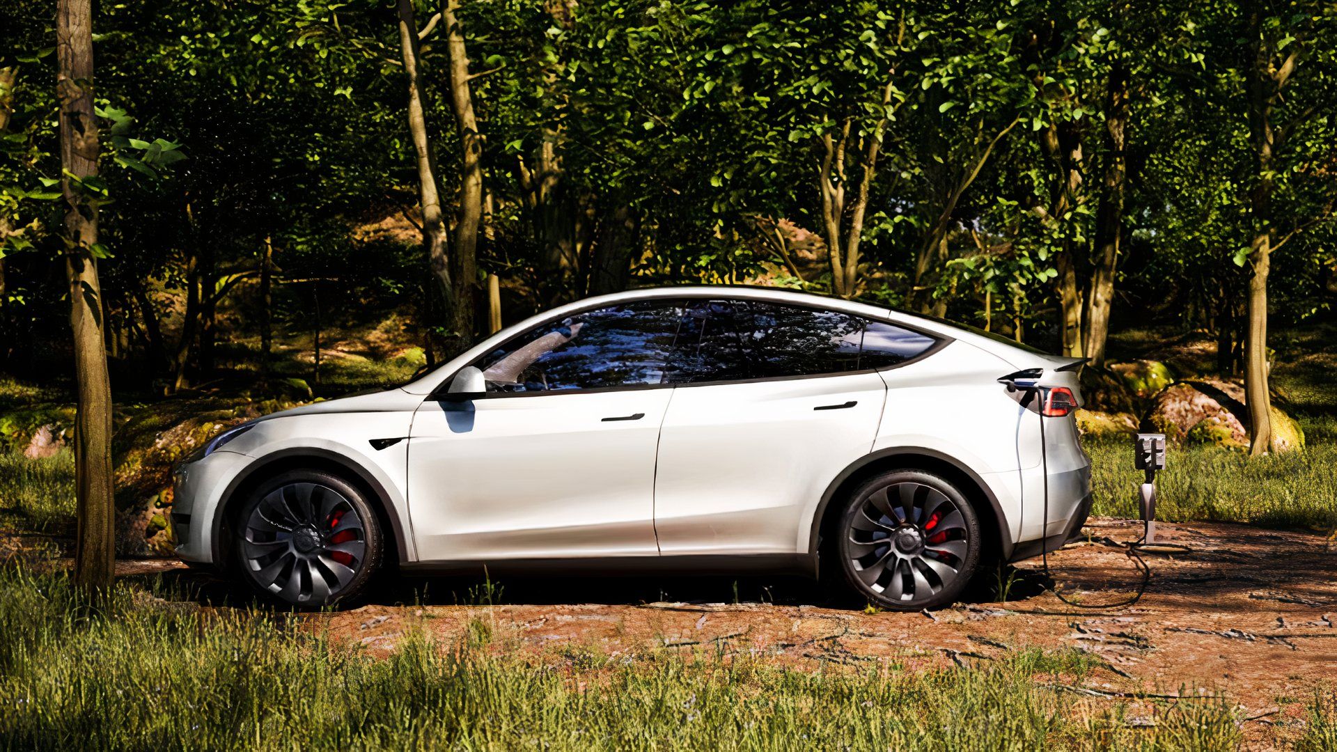 A white Tesla Model Y small electric SUV is charging outdoors. 