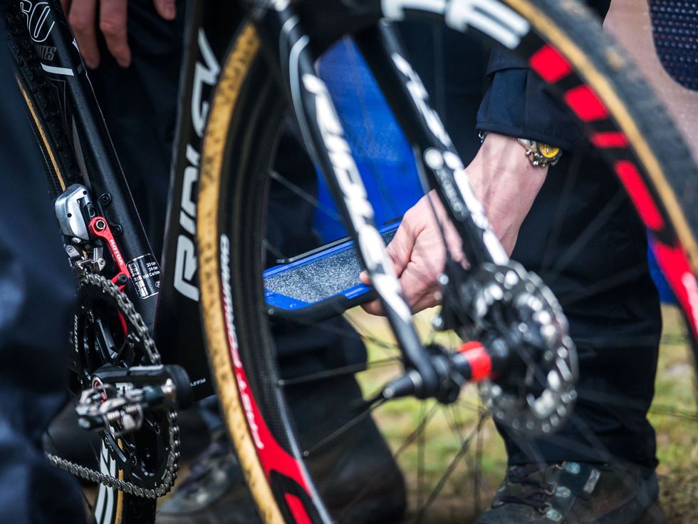 closeup of person holding a large ipad up to the chain of a bike