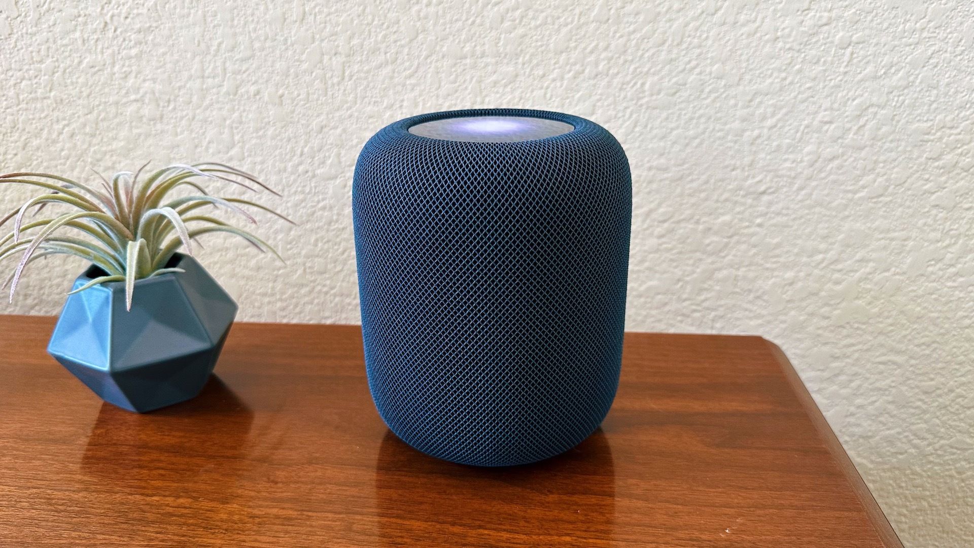 A second-gen full-sized HomePod on a table.