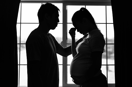 Depressed stressed out married couple talking at home. Pregnancy problems.