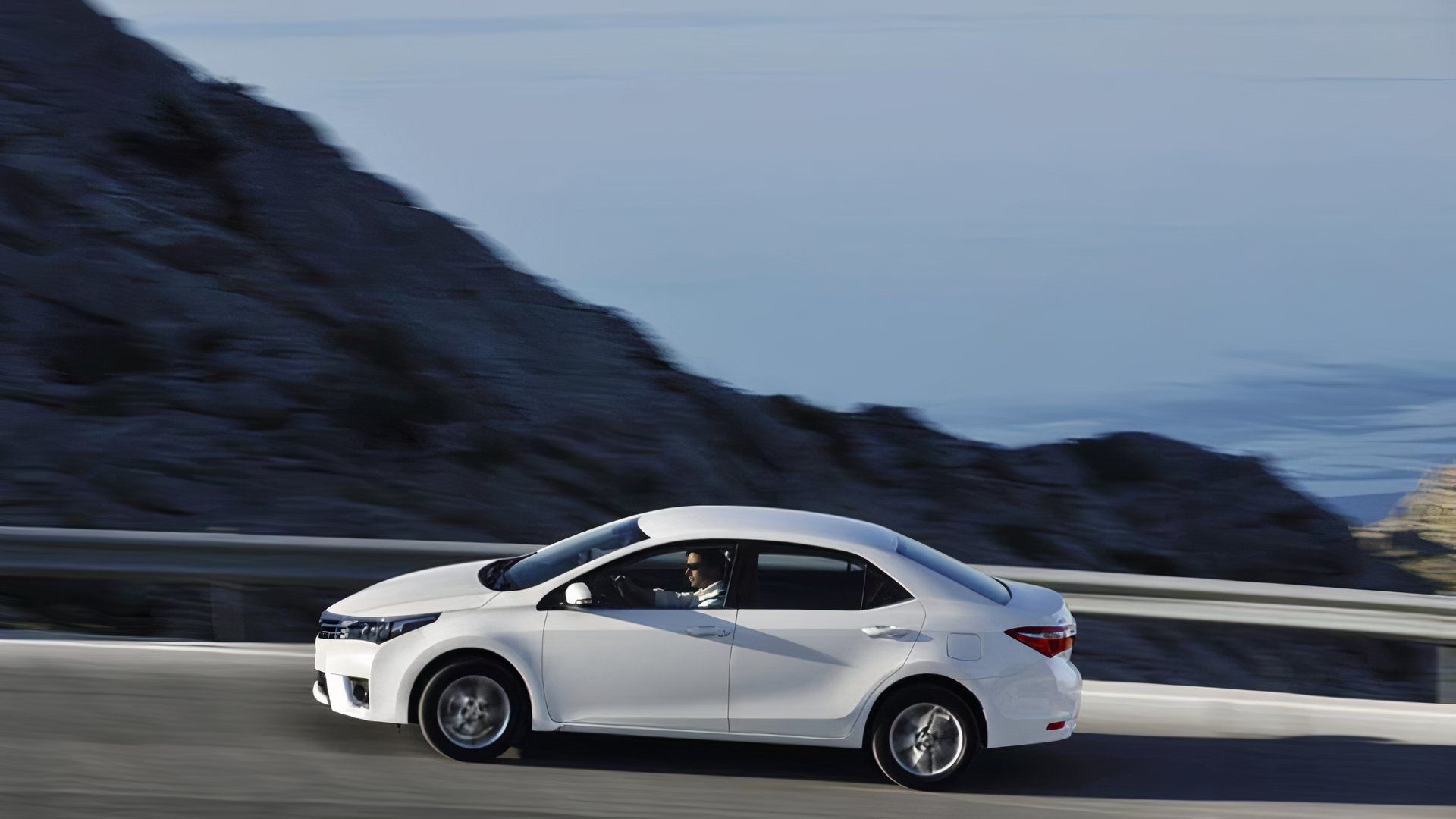 2 2013 Toyota Corolla In white Driving on mountain road