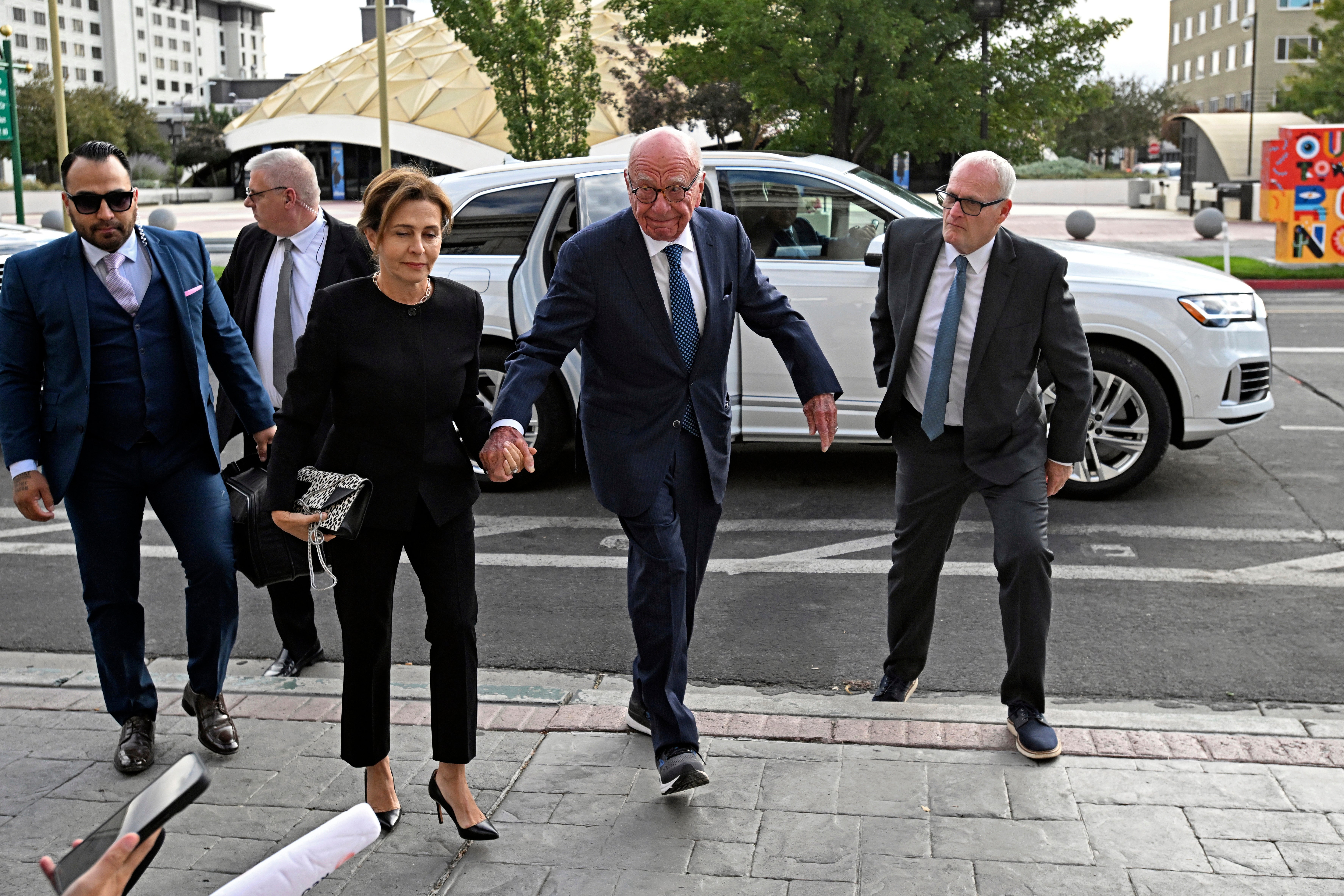 Rupert Murdoch, center, and his wife Elena Zhukova Murdoch arrive at the court in September