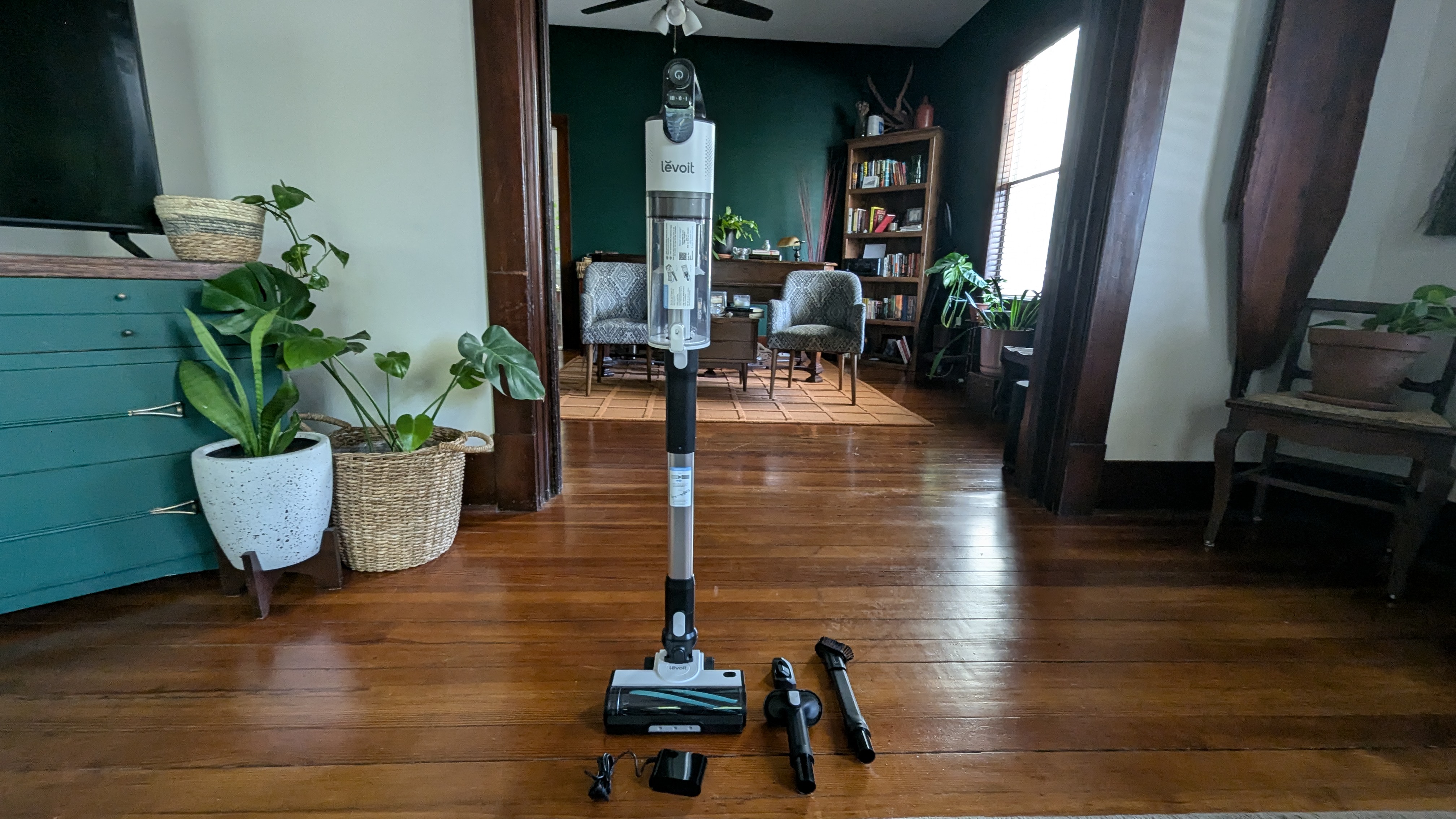 Levoit LVAC-200 cordless vacuum, standing upright, next to supplied accessories, in reviewer's home