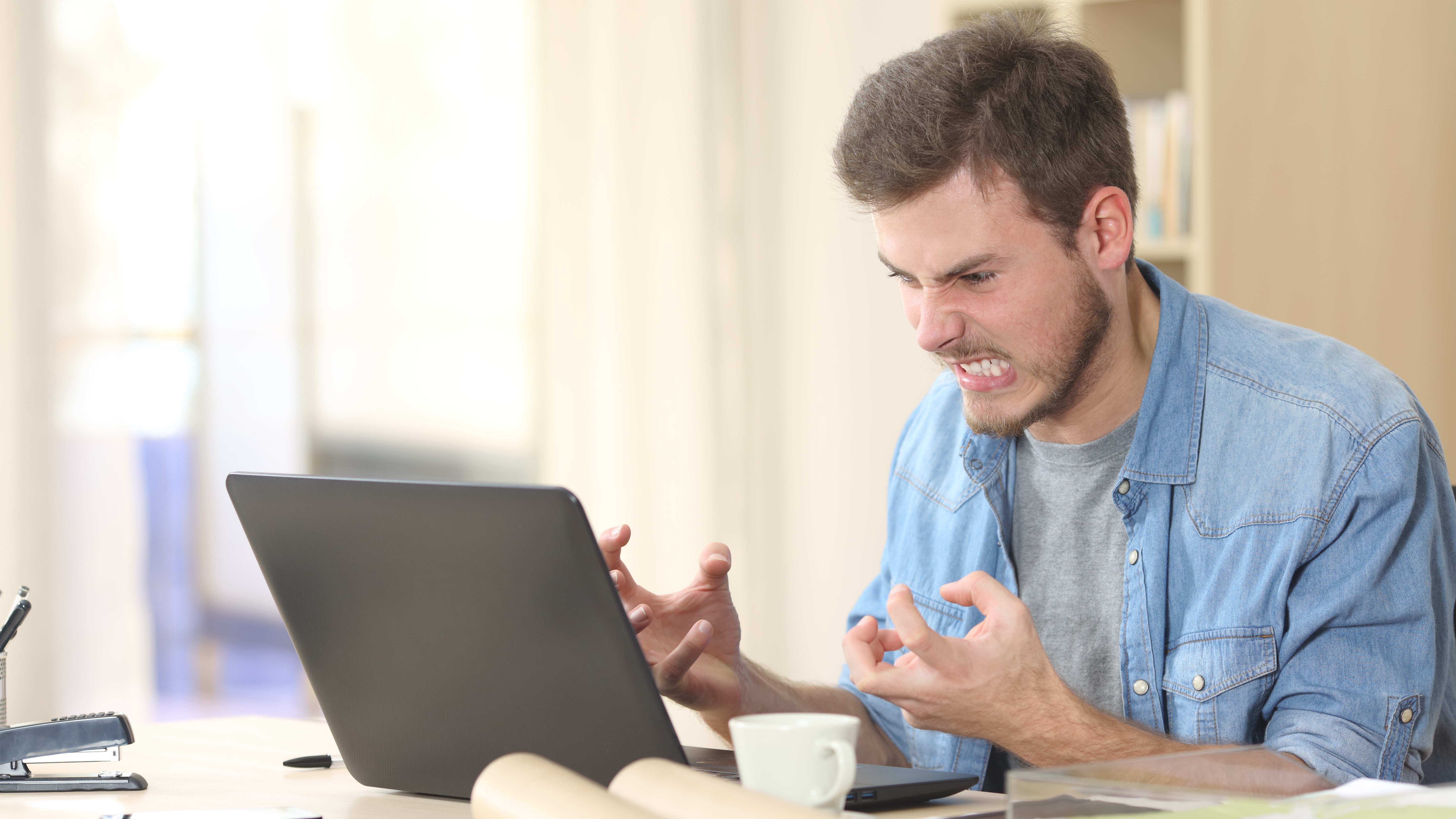 A man getting angry with his laptop.