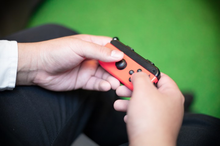 Four Joy-Con controllers next to a Switch.