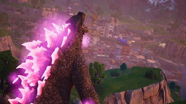 Godzilla with pink glowing scales roaring as it stands over a cityscape in Fortnite