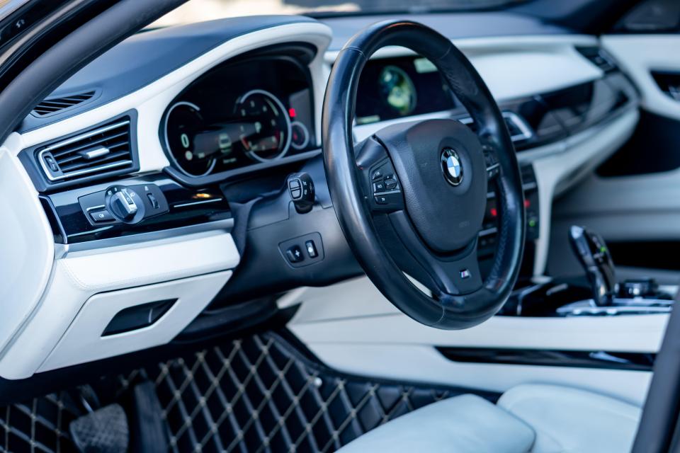 Luxury German car interior with white leather seats and black trim.