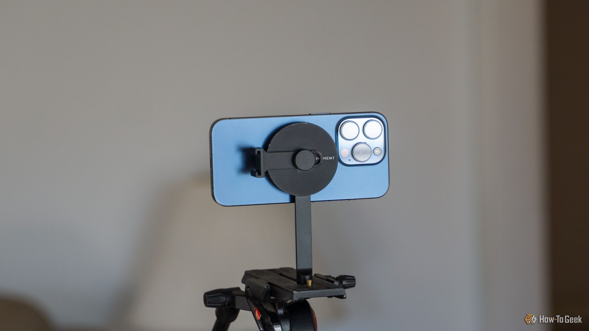 An iPhone 15 Pro mounted horizontally on the Moment MagSafe Tripod mount.