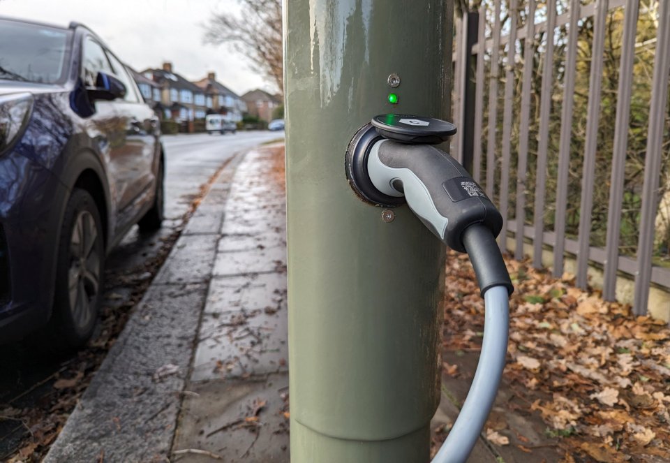 Electric vehicle charging at a converted streetlight.