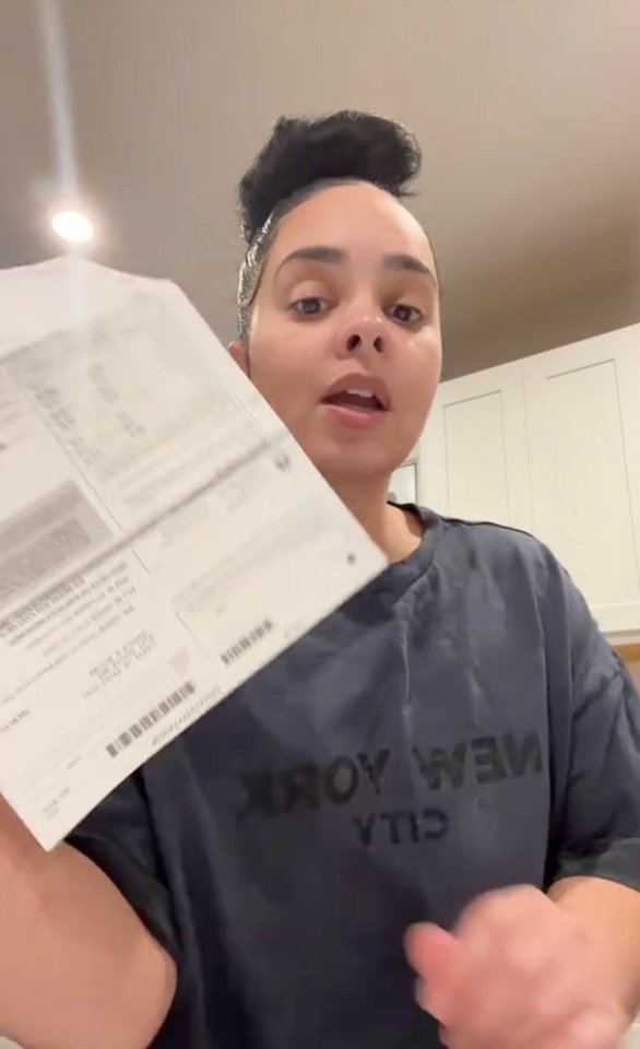 Woman holding a car registration renewal notice and expressing outrage at the $200 fee.