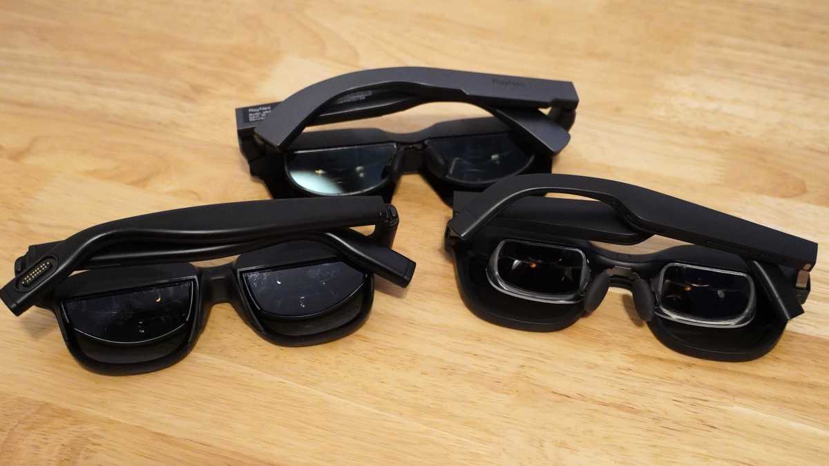 Three different AR XR glasses on a wooden table