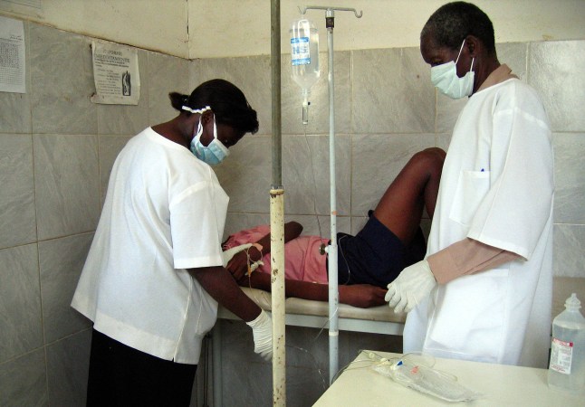 Angolan health workers treat, 05 April 2005, a 22-year-old woman, a new suspected case of the Marburg haemorrhagic fever in a clinic in Cacuaco township, outside Luanda, where the Ebola-like virus s killed at least 155 people. Angolan health workers in a slum outside Luanda were treating a new suspected case of the Marburg virus on Tuesday as a senior UN official warned that the outbreak of the Ebola-like epidemic was not yet under control. Nurses at a clinic in the township of Cacuaco, some 18 kilometers (11 miles) north of the capital, were scrambling to help the 22-year-old woman who they feared may be the latest casualty of the haemorrhagic fever which has so far claimed 155 lives in the biggest outbreak ever of the disease. AFP PHOTO/FLORENCE PANOUSSIAN (Photo by Florence PANOUSSIAN / AFP) (Photo credit should read FLORENCE PANOUSSIAN/AFP via Getty Images)