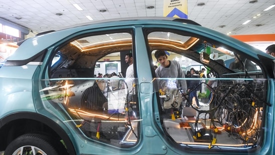 A guest at the exhibit looks into the inside of a car which has all its wires and inner workings exposed as part of a display at the expo(Amit Sharma)