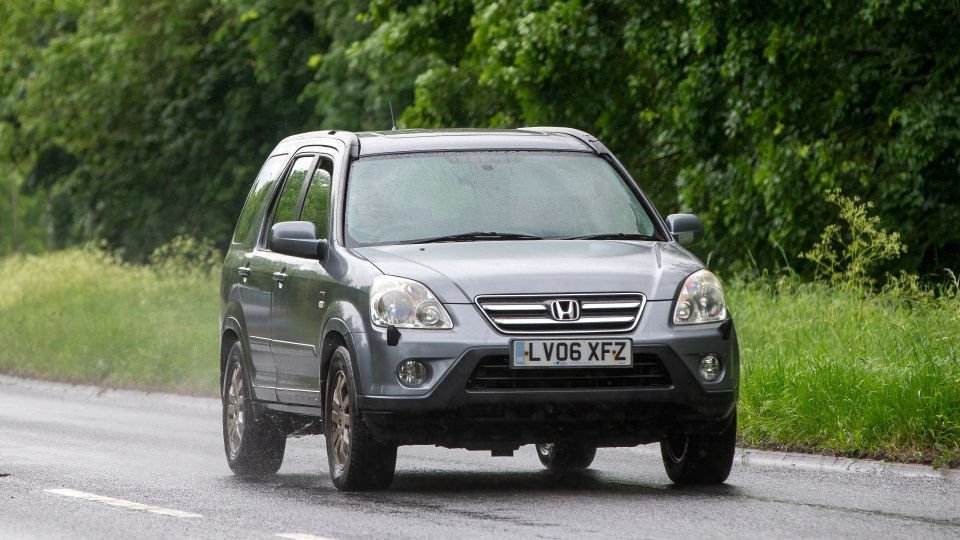 A gray 2006 Honda CR-V driving on a wet road.