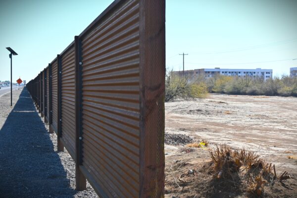 The new corrugated metal wall on Maricopa-Casa Grande Highway separates the road from the apartments behind it. Just to the east, more apartment buildings are under construction. Photographed Jan. 30, 2025. [Elias Weiss]