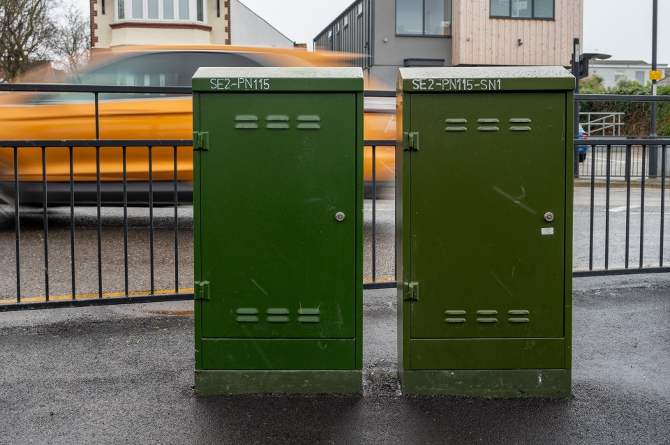 Two green metal cabinets for broadband and phone cabling.