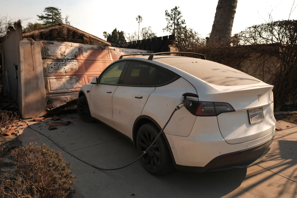 A Tesla car with its charger still attached in the driveway of building destroyed by the Eaton Fire, in Altadena. Photo: AP