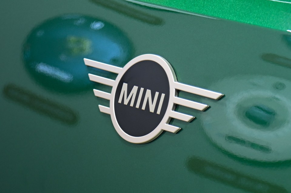 Mini Cooper logo on a green car.