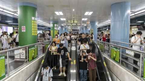 Commuters ride escalators at a subway station in Guangzhou