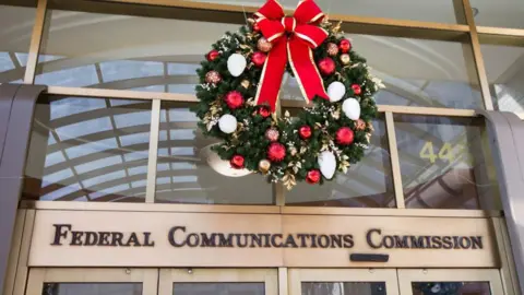 Getty Images A Christmas wreath hangs above the entry to the Federal Communications Commission office