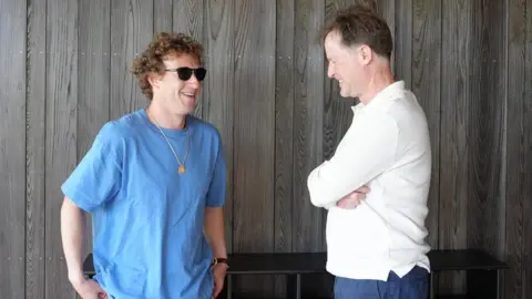 Meta Mark Zuckerberg, chief executive of Meta, in a blue T-shirt and sunglasses, with Sir Nick Clegg in a white long-sleeve T-shirt, both laughing