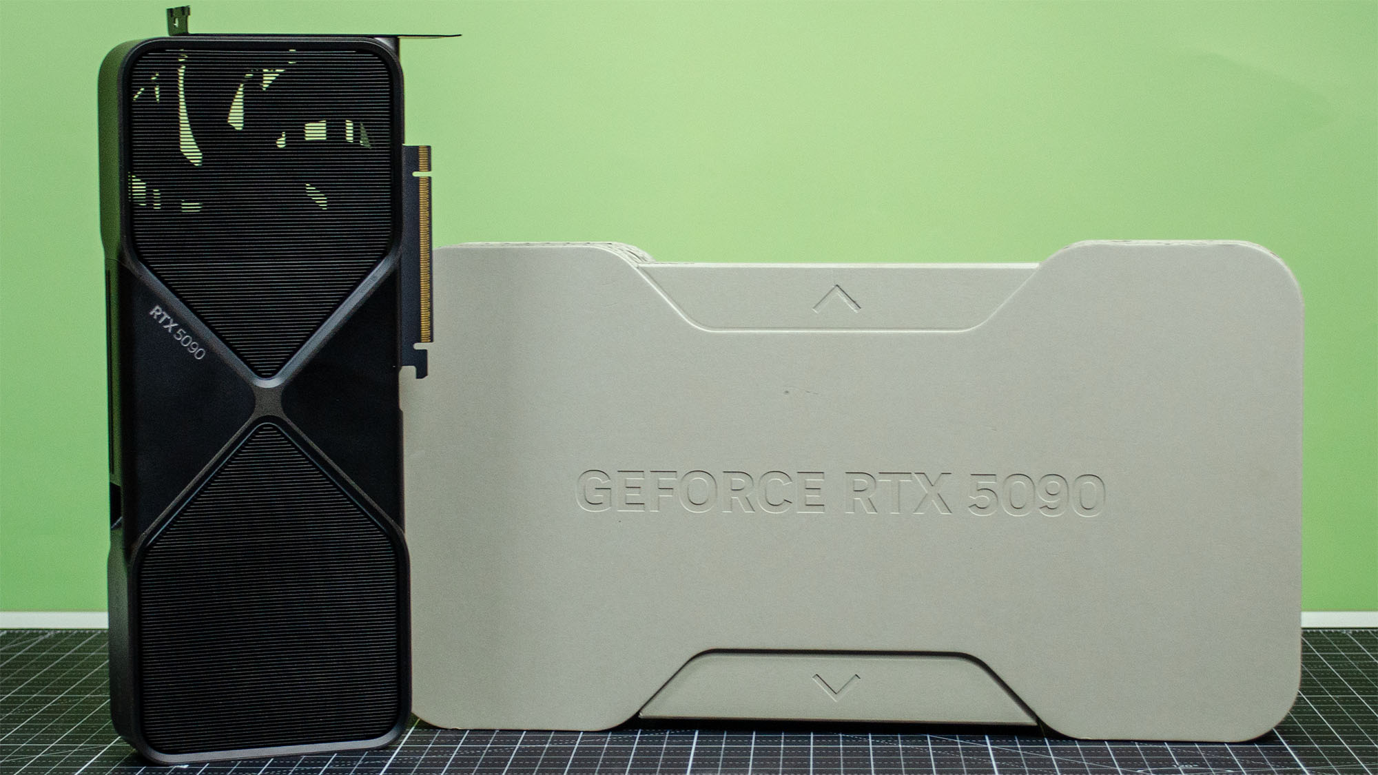 An Nvidia GeForce RTX 5090 on a desk next to its retail packaging