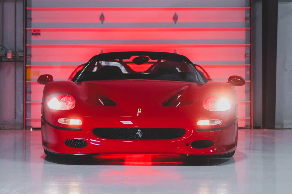 Red Ferrari F50 in a garage.