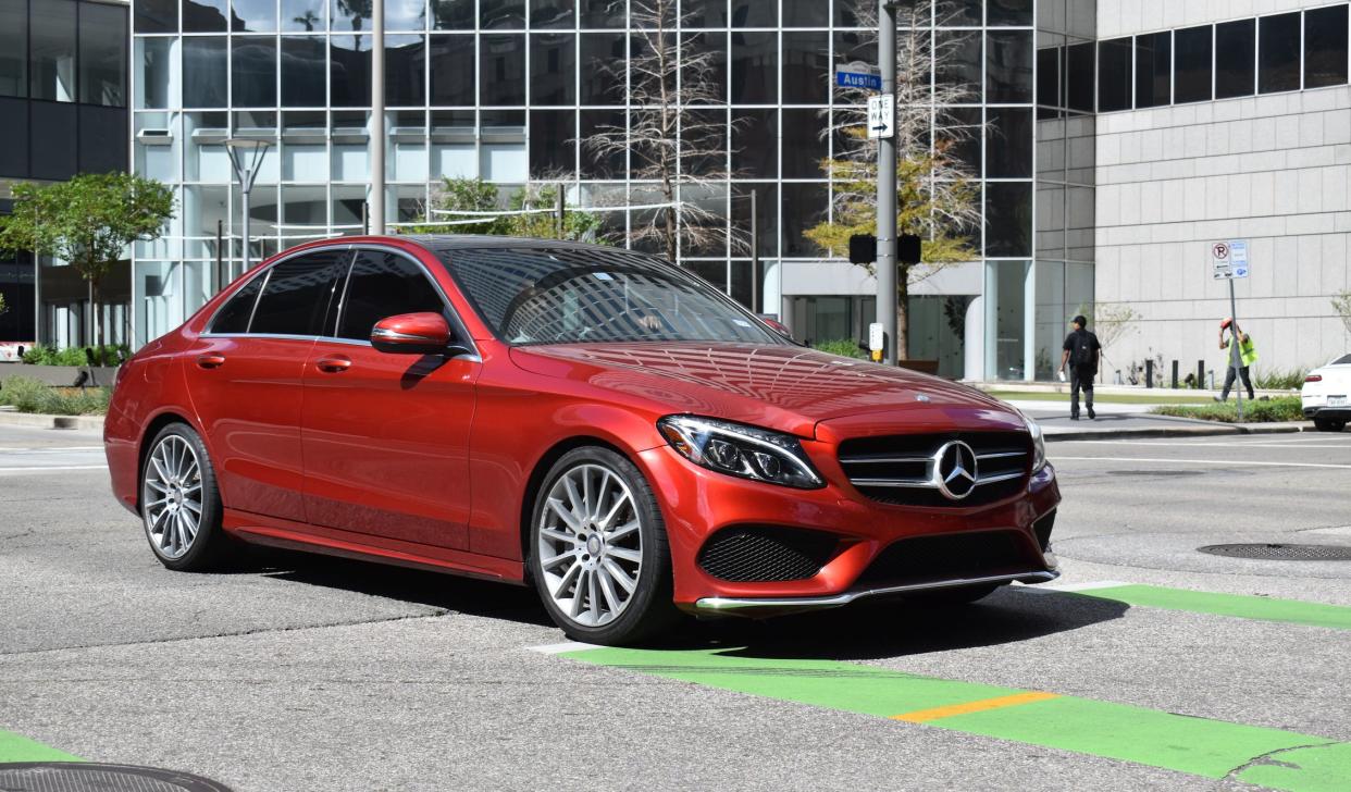 Houston, TX USA 10-4-2024 -   A red Mercedes-Benz C350 4matic AMG luxury sedan, cruising in the downtown financial district of the city.