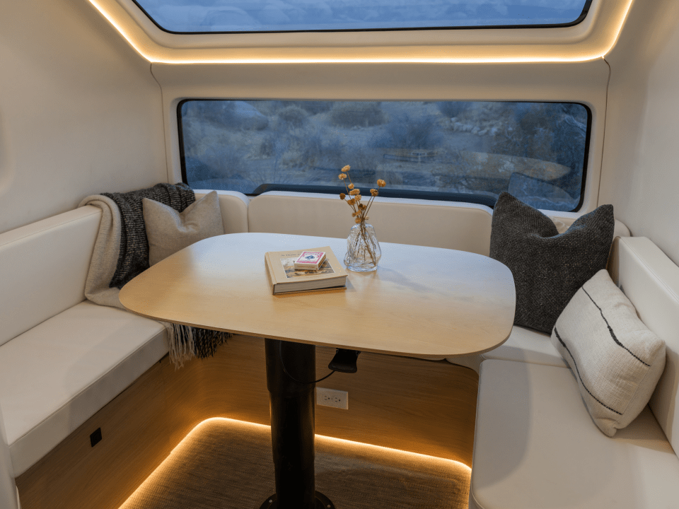 Interior of an electric caravan with a table and seating area.