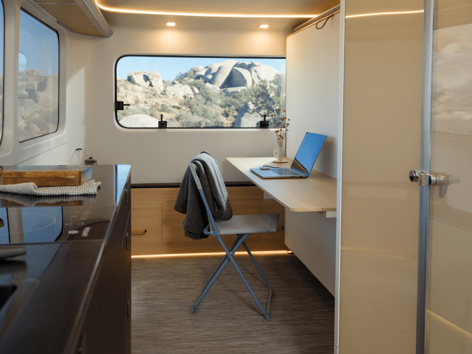 Interior of an electric caravan with a workspace.