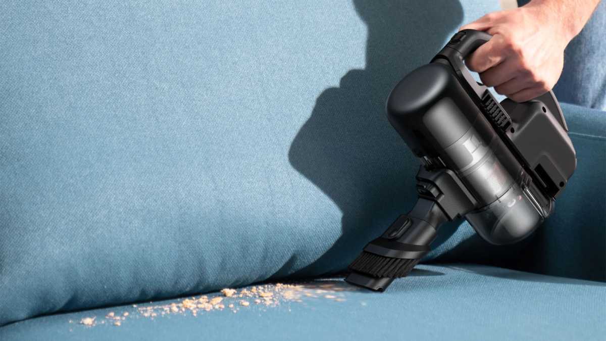 Eufy E20 in handheld mode, vacuuming a sofa