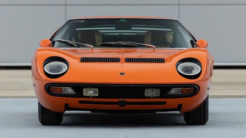 The bright orange exterior, USA, YOU COULD OWN this rare 1971 Lamborghini Miura P400 SV for ¿4M at auction. Images show this stunning Lamborghini finished in a unique combination of Arancio Miura or Miura Orange paintwork over a retro Goby sand interior. The Miura SV is one of only about 150 of its kind ever built, making it an incredibly rare find for collectors. One of the first 25 cars built, this Miura features early design elements such as the absence of ¿ears¿ on the wheel spinners and bodywork slats with rounded edges, marking it as a distinctive early example of the SV. This particular model is further distinguished by its European specification, devoid of U.S. specific safety features like side repeaters, and it is equipped with a matching numbers chassis and engine. Chassis No. 4854 and Engine No. 30647 trace a fascinating history, beginning with its delivery in July 1971 to Hubert Hahne, a renowned German racing driver and Lamborghini agent. This Miura has an illustrious provenance, having been part of the Rosso Bianco Collection for over three decades, where it shared space with some of the finest sports cars in the world. The car¿s remarkable journey included ownership by notable figures, such as former racing driver Peter Kaus. The meticulous nut-and-bolt restoration took place between 2014 and 2016 and cost close to ¿250K. It was carried out by award-winning Modenese Lamborghini experts, including Carrozzeria Cremonini handling the bodywork and Top Motors working on the mechanicals, alongside other industry leaders. The 1971 Lamborghini Miura P400 SV is set to be auctioned at The Amelia Auction in 2025. ¿The car's striking original colours were briefly altered, as records show it was painted in Luci del Bosco Green before its first private owner, but it has since been restored to its original Miura Orange exterior. "By the early 1980s, the car was acquired by former racing driver and renowned collector Peter Kaus," who added it to his world-famous collection. ¿During this time, the car showed around 60,000 kilometers, believed to be original, before it was sold and carefully restored. "Any Miura SV is a rare motorcar. ¿But an SV such as this, restored to its original and correct specification by the very best craftsmen in Modena, is truly a rare opportunity." ENDS