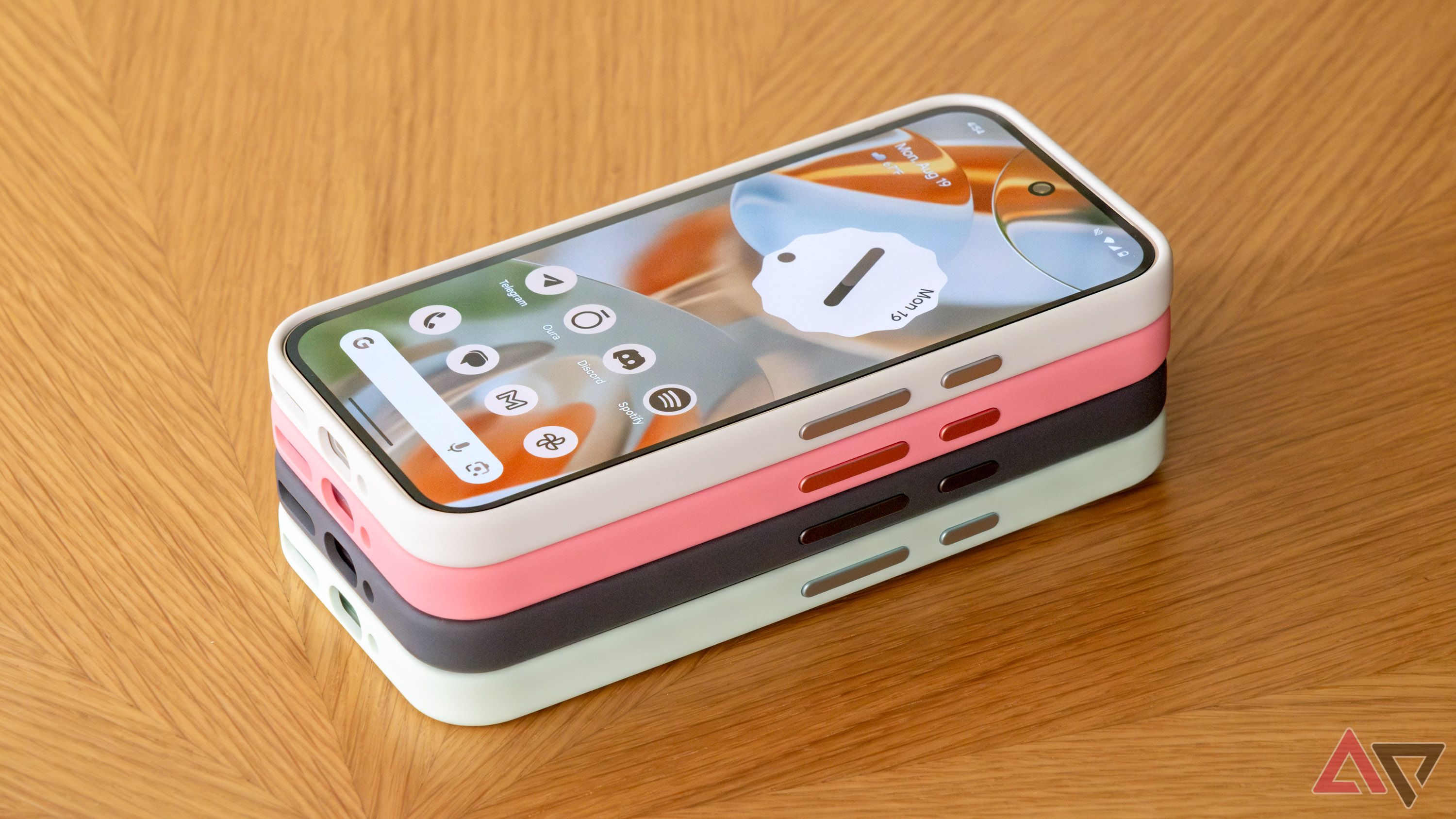 A smartphone in a case stacked on top of other phone cases.