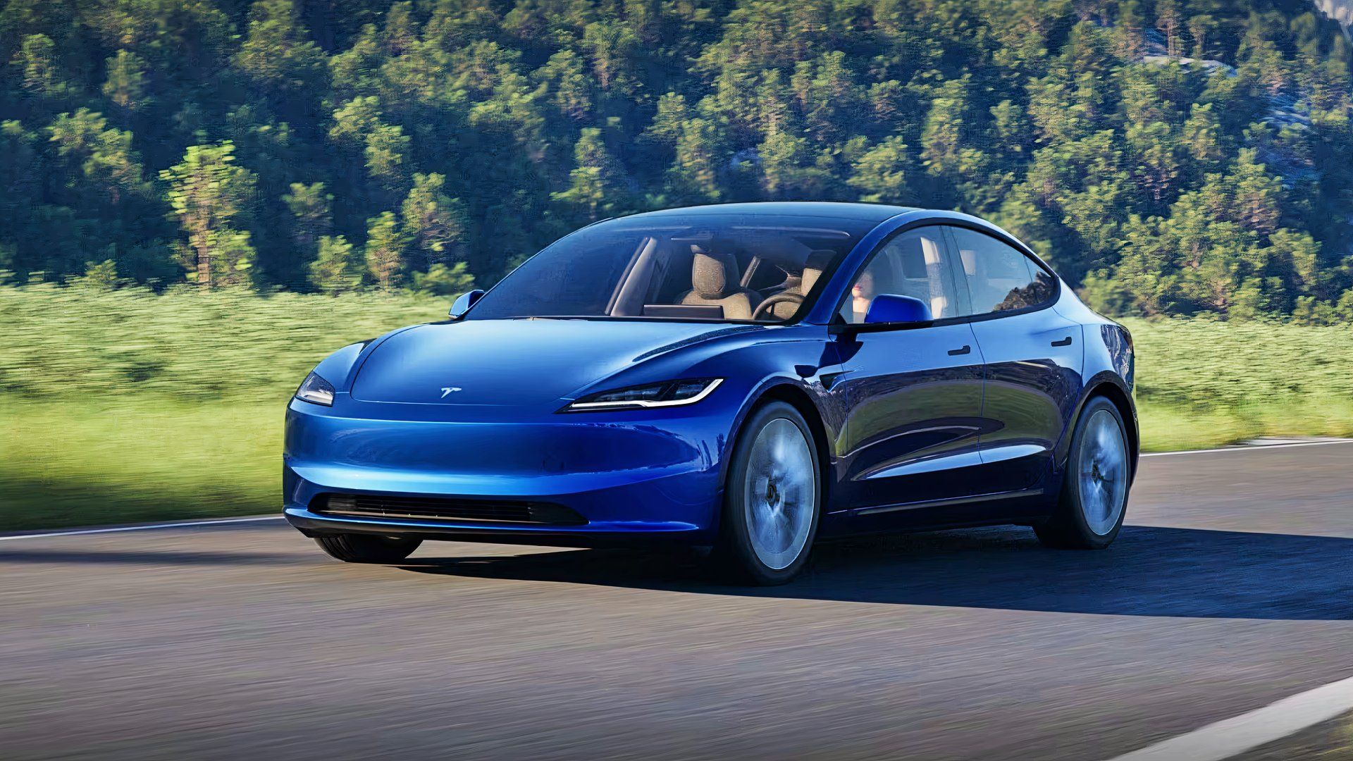 A blue 2025 Tesla Model 3 is driving on the road. 