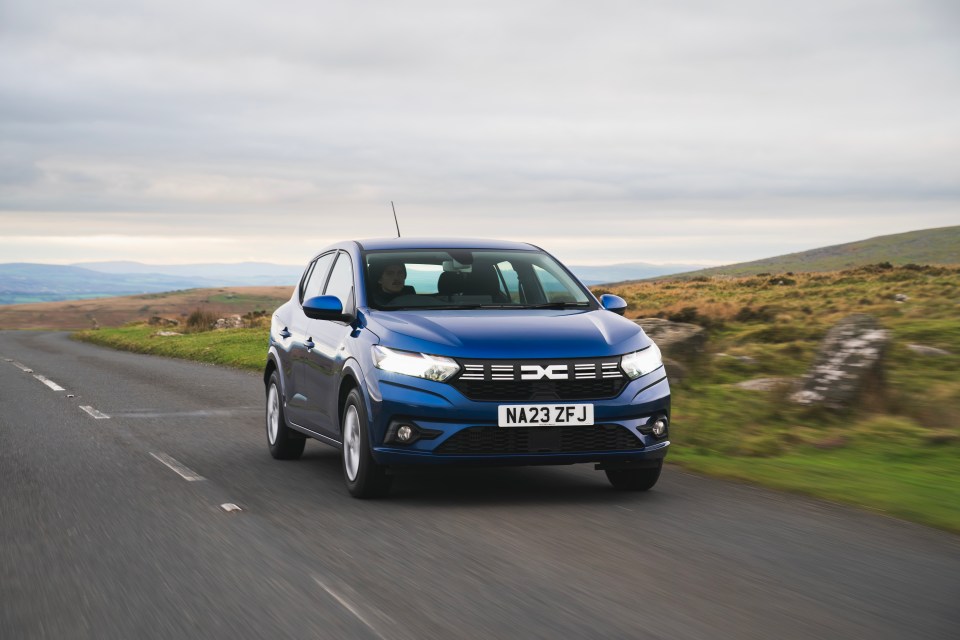 Blue car driving on a road.