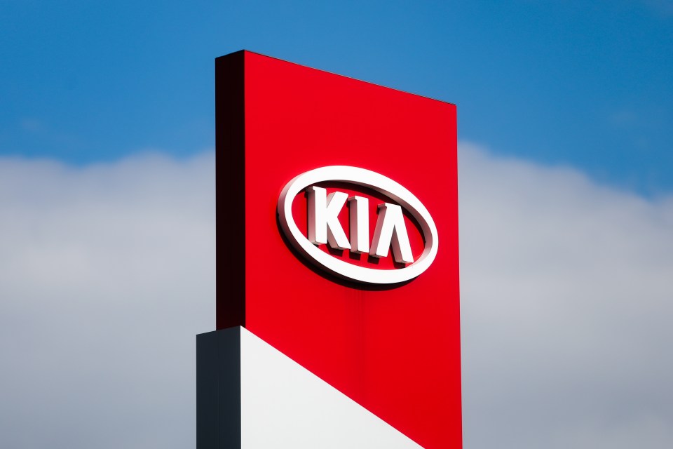 Kia logo on a red and white sign.