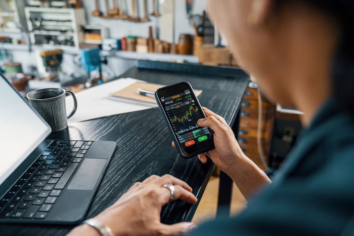 An individual looking at a stock chart on a phone.